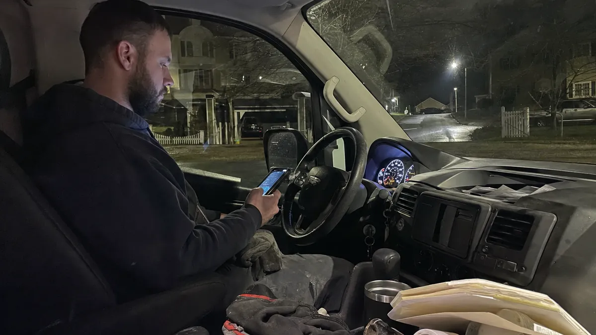 A smartphone glowing with a late-night incoming call on a dark nightstand