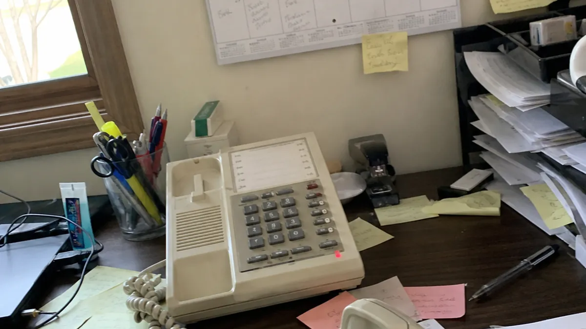 Three phones ringing at once on a desk in the morning rush